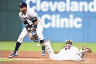  ??  ?? José Ramírez, de los Indios, se desliza de cabeza en segunda para llegar quieto ante el vano intento del intermedis­ta Starlin Castro, de los Yankees, por retener el disparo del receptor.