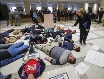  ?? AP PHOTO/MARK WALLHEISER ?? Florida Rep. Janet Cruz (D-Tampa) walks around a group of 20 college students and activists as they stage a die-in on the 4th floor rotunda between the House and Senate chambers while the House takes up the school safety bill at the Florida Capital in...