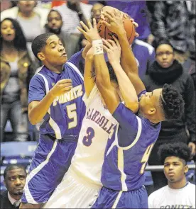  ?? PHOTOS BY MARC PENDLETON / STAFF ?? Carroll’s Stafford Stevens (3) is squeezed by Ponitz defenders Jalen Garrett (5) and Malik Pooler during the Patriots’ 45-43 win at UD Arena.