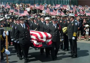  ??  ?? in this Aug. 20, file photo, the casket with fallen Utah firefighte­r Matthew Burchett is loaded into a fire engine after the funeral at the Maverik Center in West Valley City, Utah. RIck Egan/ThE SalT lakE TRIBunE VIa aP