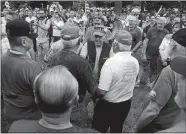  ?? SARAH GORDON/THE DAY ?? Veterans greet one another before the national anthem is played during a rally in support of the American flag on Monday at Higganum Town Green.