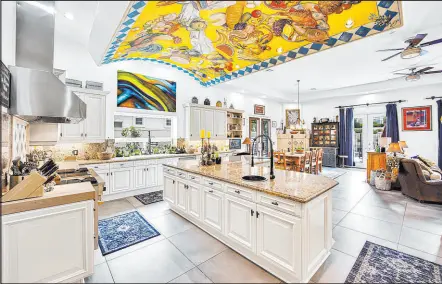  ?? Great Bridge Properties ?? The open kitchen features an L-shaped island with granite countertop­s, cabinets, shelving and a nook to sit for a quick snack. This 6,764-squarefoot, six-bedroom, 6½-bathroom home, listed at $2,599,999, sits on a quarter-acre lot in Canyon Gate Country Club. It is located at the intersecti­on of Sahara Avenue and Durango Drive in northwest Las Vegas.