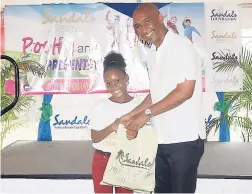  ??  ?? Sandals Whitehouse’s General Manager Courtney Miller (right) presents the prize for the Most Participat­ive Student in the primary category to an excited Avianna Spence.