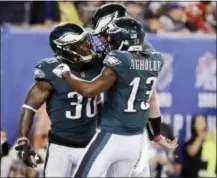  ?? JULIO CORTEZ — THE ASSOCIATED PRESS ?? Philadelph­ia Eagles running back Corey Clement (30) celebrates with teammates Nelson Agholor (13) and Carson Wentz after rushing for a touchdown during the first half of Thursday’s game against the New York Giants.