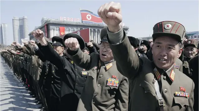  ?? JON CHOL JIN/ THE ASSOCIATED PRESS ?? North Korean army officers chant slogans during a rally at Kim Il Sung Square in downtown Pyongyang Friday. Tens of thousands of people turned out in support of their leader’s call to arms.