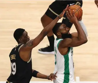  ?? Getty IMaGes; aBove, ap pHotos ?? TOUGH HOMECOMING: Atlanta native Jaylen Brown is blocked by Hawks defender Tony Snell, left, on Wednesday night in Atlanta, Ga. Coach Brad Stevens, top right, lowers his mask to talk to his team from the sideline. Above left, Jeff Teague, getting the start after four straight games of being a healthy scratch, passes out of a double-team initiated by Atlanta ballhawker Trae Young.