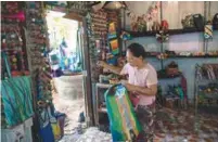  ??  ?? Wendy Neampui arranges craft made out of recycled plastics at her Chu Chu recycling shop in Dala, on the outskirts of Yangon.