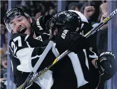  ?? HARRY HOW/GETTY IMAGES ?? Alec Martinez of the Los Angeles Kings hugs Anze Kopitar following his overtime goal to beat the Canucks at Staples Center.