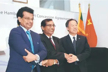  ??  ?? Managing director of China Merchants Port Holdings Dr Bai Jingtao (right) shakes hands with Secretary to the Ministry of Port L.P.Jayampathi (center) and chairman of Sri Lanka Ports Authority Dr. Parakrama Dissanayak­e (left) after exchanging documents...