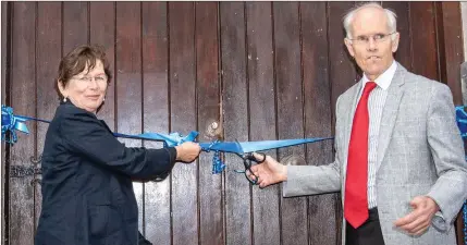  ??  ?? Mary Telford and Dr Michael Telford cutting the ribbon to officially open John Scottus School on the Old Conna Road.