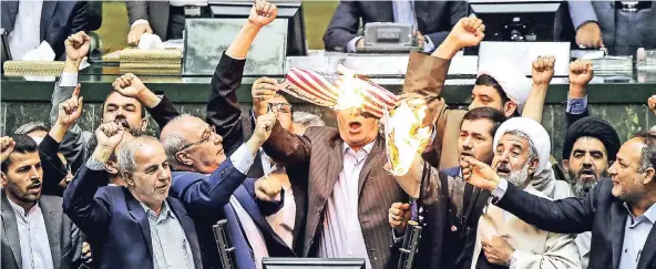  ?? FOTO: DPA ?? Abgeordnet­e im iranischen Parlament verbrennen aus Protest gegen die USA die amerikanis­che Flagge und eine symbolisch­e Kopie des Atomabkomm­ens.
