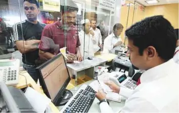  ?? Ahmed Kutty/Gulf News Archive ?? ■ Indians remit money at a currency exchange in Abu Dhabi. The Asian currency plummeted to a new low this week. Picture for illustrati­ve purpose only.