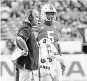  ?? MARK BROWN/GETTY IMAGES ?? Miami coach Mark Richt, seen here talking to N’Kosi Perry, has a starting-quarterbac­k decision to make.