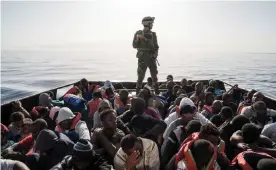  ??  ?? A Libyan coastguard official with people rescued from the sea on 27 June 2017. Photograph: Taha Jawashi/AFP/Getty