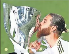  ??  ?? Sergio Ramos besando la última Liga que ha ganado con el Madrid.