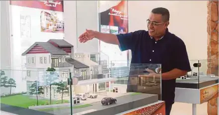 ??  ?? Putra Perdana Developmen­t general manager Badrul Hisham Kidam with a scale model of the Type B unit for the Hening project in Putrajaya.