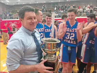  ?? GAVIN KEEFE/THE DAY ?? Coast Guard head coach Kevin Jaskiewicz, left, holds the trophy after the Bears beat host WPI 89-86 in overtime to win the NEWMAC tournament on Sunday in Worcester, Mass.