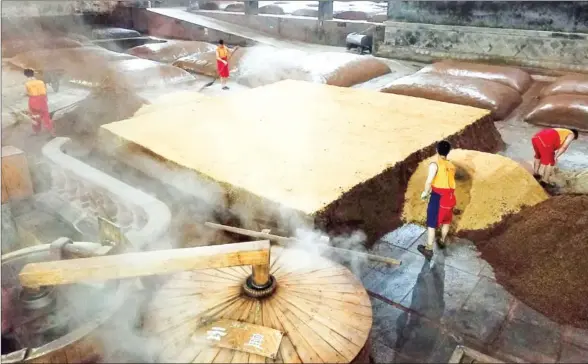  ?? HECTOR RETAMAL/AFP ?? Workers prepare and distill grain at the Luzhou Laojiao distillery where baijiu is produced in Luzhou, southweste­rn China’s Sichuan province.