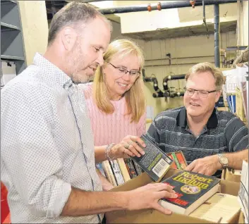  ?? MILLICENT MCKAY/JOURNAL PIONEER ?? Brad Works, left, managing editor of the Journal Pioneer, Anne MacDonald, book drive volunteer co-ordinator, and Sandy Rundle of the Rotary Club of Summerside begin sorting a box of books for the annual Journal Pioneer/Summerside Rotary Book Sale,...