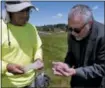  ?? RICHARD DREW — THE ASSOCIATED PRESS ?? Wade Lawrence, right, museum director and senior curator at The Museum at Bethel Woods, looks at artifacts recovered from a dig at the site of the original Woodstock Music and Art Fair, in Bethel, N.Y. Edgar Alarcon of the Public Archaeolog­y Facility at Binghamton University looks on at left.