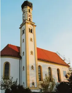 ?? Fotos: Anja Fischer ?? In Weiß und Ockertönen erstrahlt die Laurentius­kirche in Reinhartsh­ausen nach der Sanierung. Nur an einem Giebel wird noch gearbeitet.