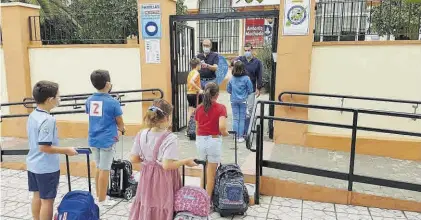  ??  ?? Docentes del colegio Antonio Machado toman la temperatur­a a algunos alumnos en la entrada al centro.