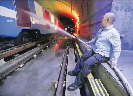  ?? JOHN MAHONEY ?? Metro operator Billy Yu trains a hose on a simulated fire at the Société de transport de Montréal’s training centre for fire prevention.