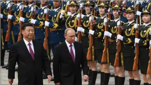  ?? GREG BAKER — AFP VIA GETTY IMAGES ?? Russia’s President Vladimir Putin, right, reviews a military honor guard with Chinese President Xi Jinping, left, during a welcoming ceremony outside the Great Hall of the People in Beijing in 2018.