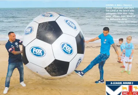  ?? Picture: GETTY IMAGES ?? HAVING A BALL: Victory's Archie Thompson and City’s Tim Cahill at the beach with youngsters from their clubs’ junior affiliate clubs ahead of the Melbourne derby.
