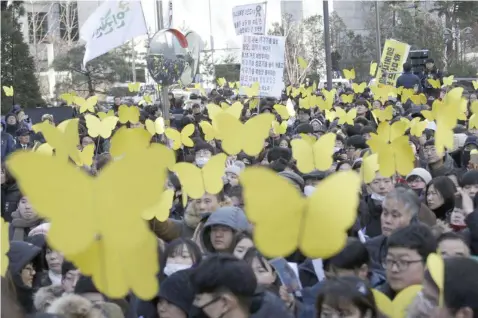  ?? (AP Photo/Ahn Young-joon) ?? Mourners hold yellow butterfly cutouts dedicated to Kim Bok-dong, a former South Korean sex slave, during her funeral ceremony in front of the Japanese Embassy in Seoul, South Korea, Friday, Feb. 1, 2019. Hundreds of mourners gathered Friday near the embassy for the funeral of Kim forced as a girl into a brothel and sexually enslaved by the Japanese military in WWII.