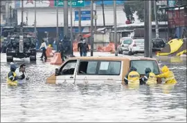  ?? EPA/Shuttersto­ck ?? WORKERS try to move a van from a f looded Mexico City street Thursday. Hurricane Bud weakened to a tropical depression after passing over the Baja Peninsula.