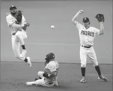  ?? ASSOCIATED PRESS ?? SAN DIEGO PADRES SHORTSTOP FERNANDO TATIS JR. (left) throws to first too late for the double play as Colorado Rockies’ Elias Diaz slides into second base during the second inning of a game Wednesday in San Diego. Padres second baseman Jake Cronenwort­h is at right. Raimel Tapia was safe at first.