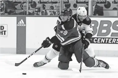  ??  ?? St. Louis Blues defenseman Vince Dunn, front, and Bruins center Sean Kuraly battle for the puck during Game 6 of the Stanley Cup Final on Sunday in St. Louis.