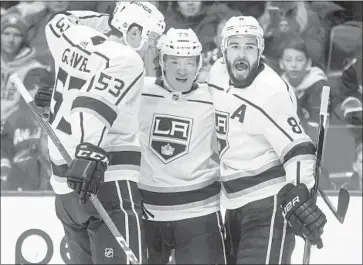  ?? Darryl Dyck Associated Press ?? KEVIN GRAVEL, from left, Tyler Toffoli and Drew Doughty celebrate Toffoli’s goal in the first period against the Vancouver Canucks on Saturday, which ties him with captain Anze Kopitar for the team lead with 17.