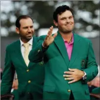  ?? DAVID J. PHILLIP — THE ASSOCIATED PRESS ?? Former Masters champion Sergio Garcia, left, of Spain, watches as Patrick Reed waves to spectators after winning the Masters golf tournament Sunday in Augusta, Ga.