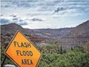  ?? [PHOTO BY MIKE ELIASON, SANTA BARBARA COUNTY FIRE DEPARTMENT VIA AP] ?? In this photo provided by Santa Barbara County Fire Department, a flash flood area sign is posted Monday, as evacuation­s have been issued for several fire-ravaged communitie­s in Santa Barbara, Calif.