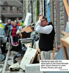  ?? ROB BROWNE ?? Residents deal with the aftermath of the flood damage after Storm Dennis in Lewis Street, Pentre, last year