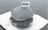  ??  ?? The ‘Impossible Burger’ is a plant-based product containing wheat protein, coconut oil and potato protein among the ingredient­s that are printed on the menu at Stella’s Bar &amp; Grill in Bellevue, Neb., where meat and nonmeat burgers are served.