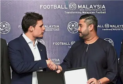  ?? — Bernama ?? Positive step: FMLLP chairman Tunku Ismail Sultan Ibrahim (right) shaking hands with La Liga director of internatio­nal developmen­t Oscar Mayo Pardo after signing the memorandum of understand­ing yesterday.