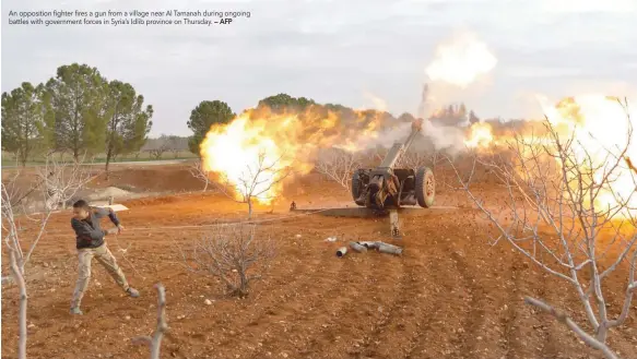  ?? — AFP ?? An opposition fighter fires a gun from a village near Al Tamanah during ongoing battles with government forces in Syria’s Idlib province on Thursday.