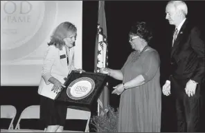  ??  ?? Stacy Hurst and Gov. Asa Hutchinson give Betty Jones an award naming Jones Bar-B-Q Diner of Marianna one of the first members of the Arkansas Food Hall of Fame.