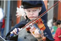  ??  ?? With furrowed brow, Joseph Gibson, 7, kept his eyes on his brother, Peter, as they perform.