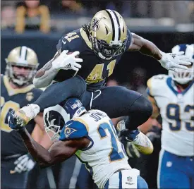  ?? BILL FEIG/AP PHOTO ?? New Orleans running back Alvin Kamara (41) leaps over Los Angeles Rams free safety Lamarcus Joyner (20) during the Saints’ 45-35 victory on Sunday.