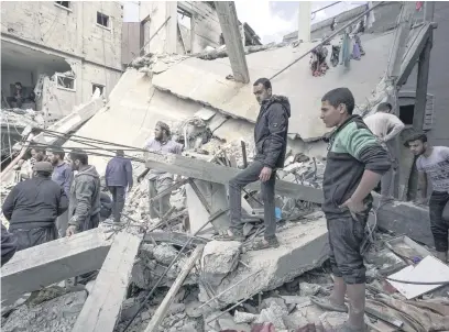  ?? Picture: AFP ?? SHELLED. Palestinia­ns inspect the rubble of a building in Deir el-Balah following Israeli bombardmen­t in the central Gaza Strip yesterday.