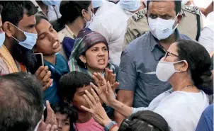  ?? ANI ?? FIRED UP (From extreme left) The burnt remains of Fatik Sheikh’s house at Bagtui village of Birbhum district; CM Mamata Banerjee meets family members of the deceased