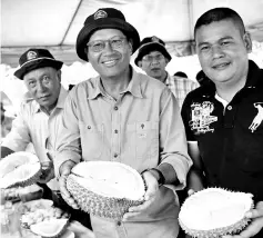  ??  ?? Ahmad Shabery (centre), showing the ‘Musang King' durian after attending a ceremony to plant the 500,000th Musang King tree at the Raub Durian Cluster, in Kampung Pamah Rawa, Ulu Dong in Pahang. - Bernama photo