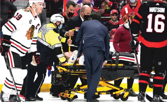  ?? JUSTIN TANG/AP ?? Blackhawks defenseman Connor Murphy is taken off the ice on a stretcher after being rammed into the boards by Senators forward Parker Kelly during the first period Saturday in Kanata, Ontario.