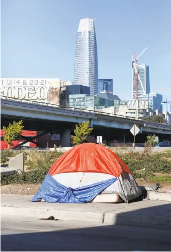  ?? Amy Osborne / Special to The Chronicle ?? With the new Salesforce tower rising in the background, one tent from an encampment is perched on a sidewalk on Fifth Street in South of Market, near the on-ramp to Interstate 80.