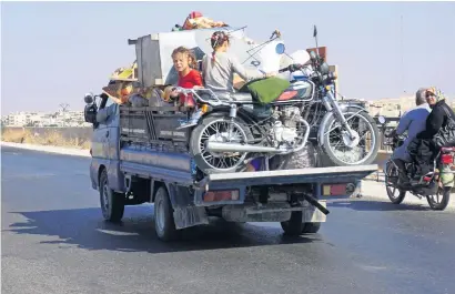  ?? AFP ?? Syrian children ride on the back of a loaded truck along the main Damascus-Aleppo highway near the town of Saraqib, in Idlib. —
