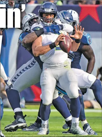  ?? GETTY IMAGES ?? Seahawks quarterbac­k Russell Wilson gets wrapped up and sacked by the Tennessee Titans during the second half yesterday in Nashville. The Seahawks lost 33-27.